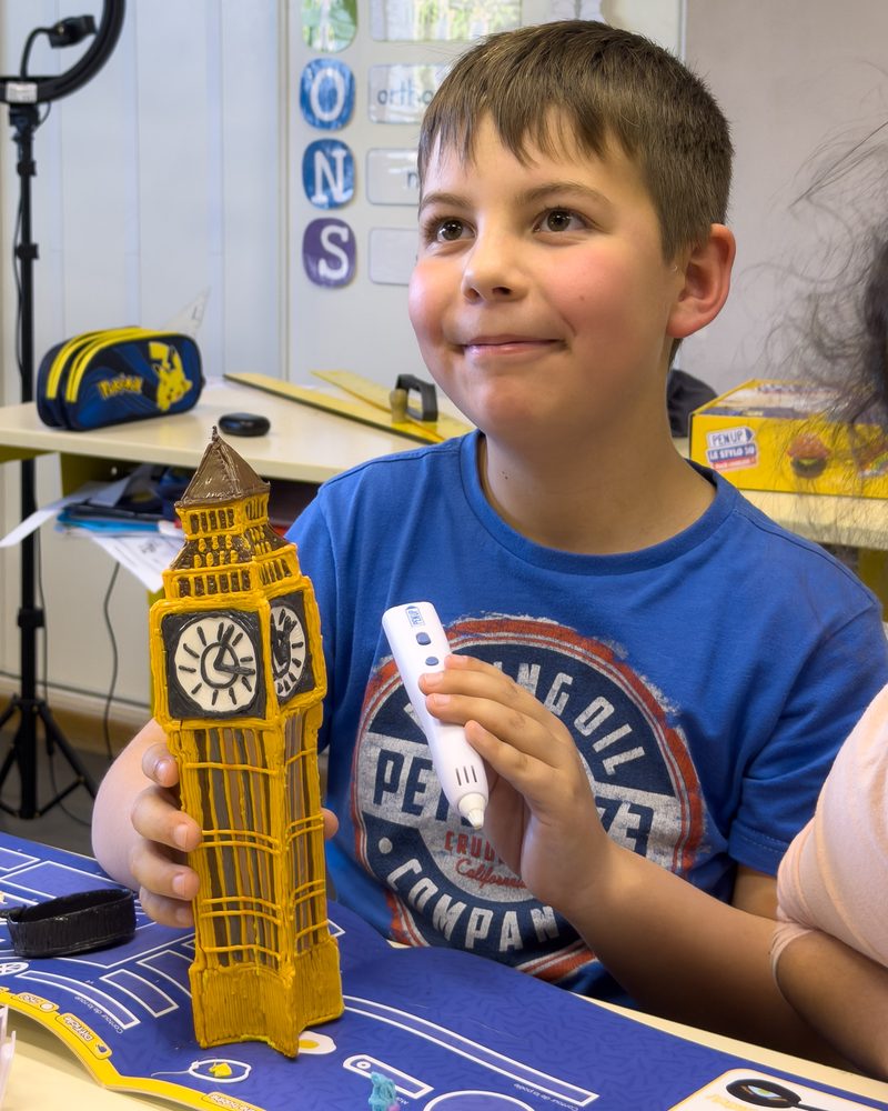 Un enfant montre sa maquette de Big Ben réalisée au stylo 3D